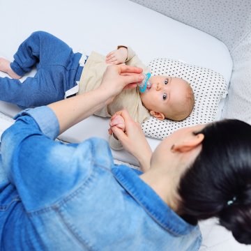 Baby in crib with mom looking over the side